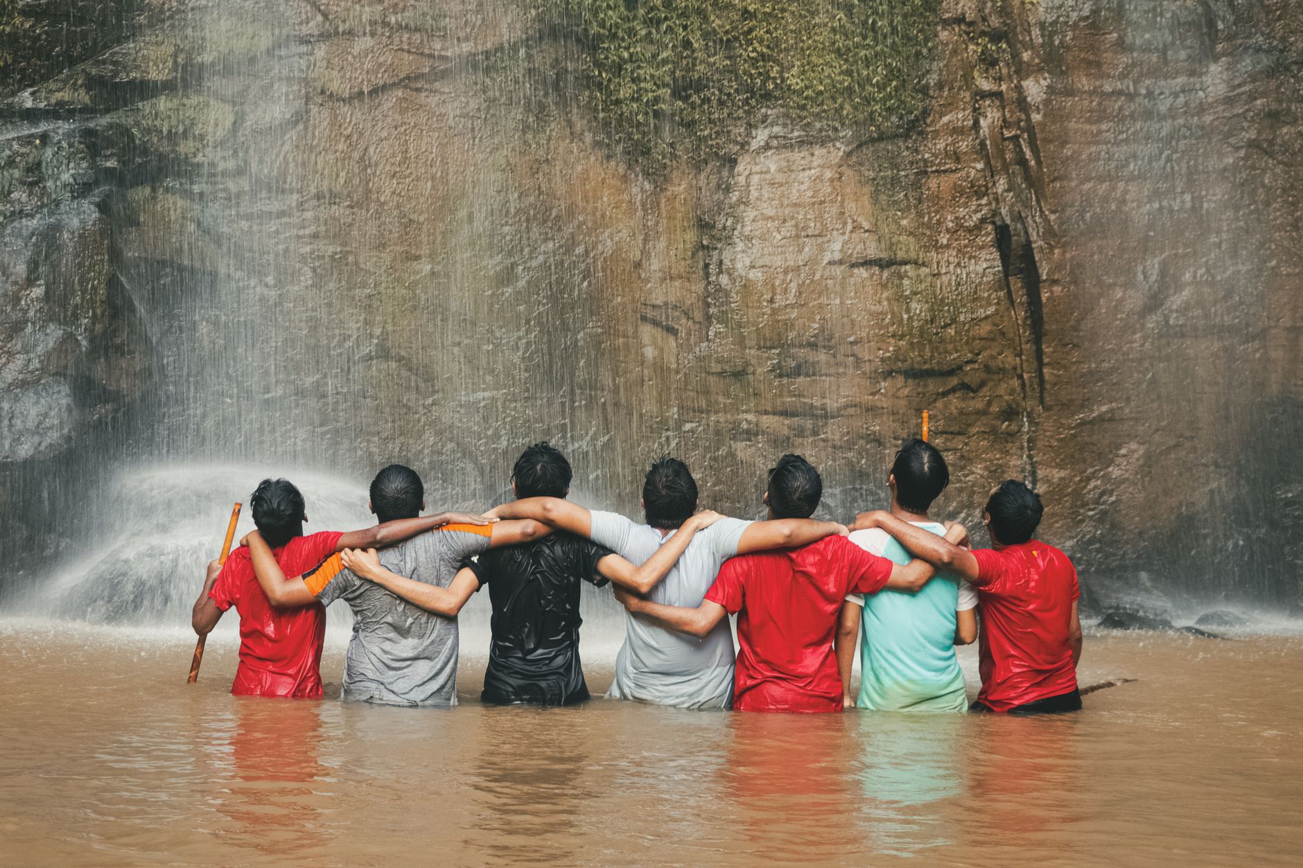Friends with arms around each other's shoulders, outdoors